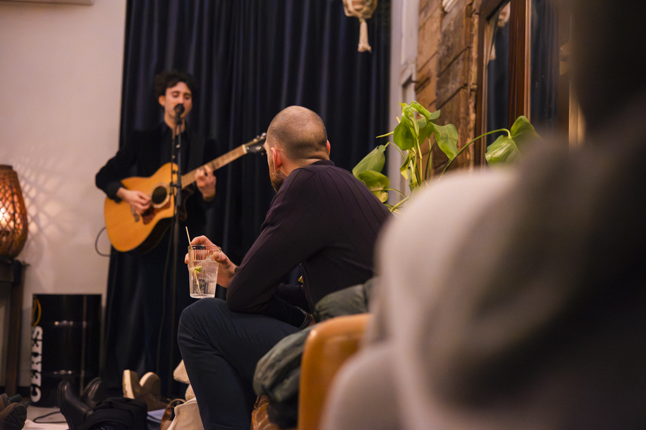 Artista in acustico e pubblico in primo piano: scena di Velluto Sonoro al Borghetto.